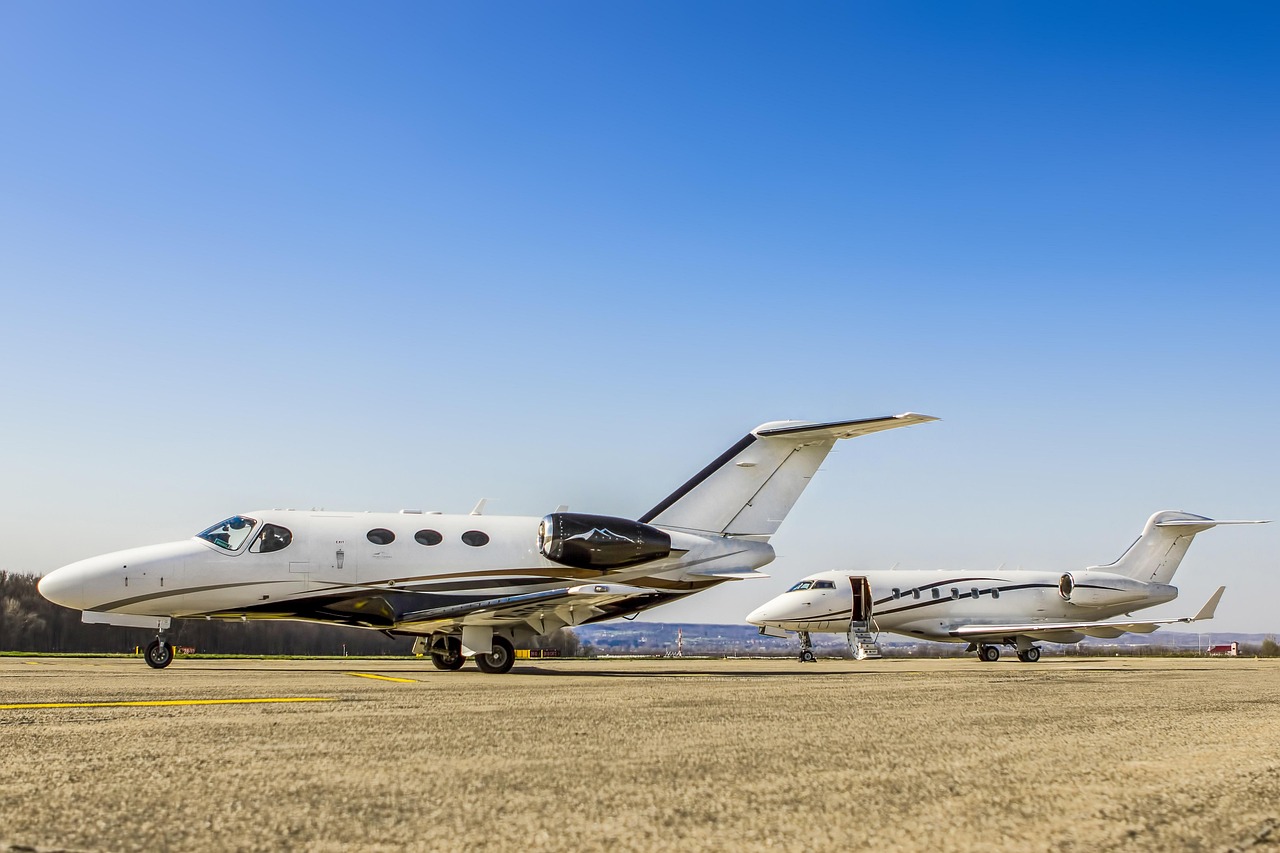 Two private business jets parked on an airport apron under a clear blue sky, representing Cabin Upgrade Financing, turbine engine financing, air charter business loans, aircraft investment financing, and compact business jet financing for aviation entrepreneurs, charter operators, and aircraft owners seeking aviation funding solutions.