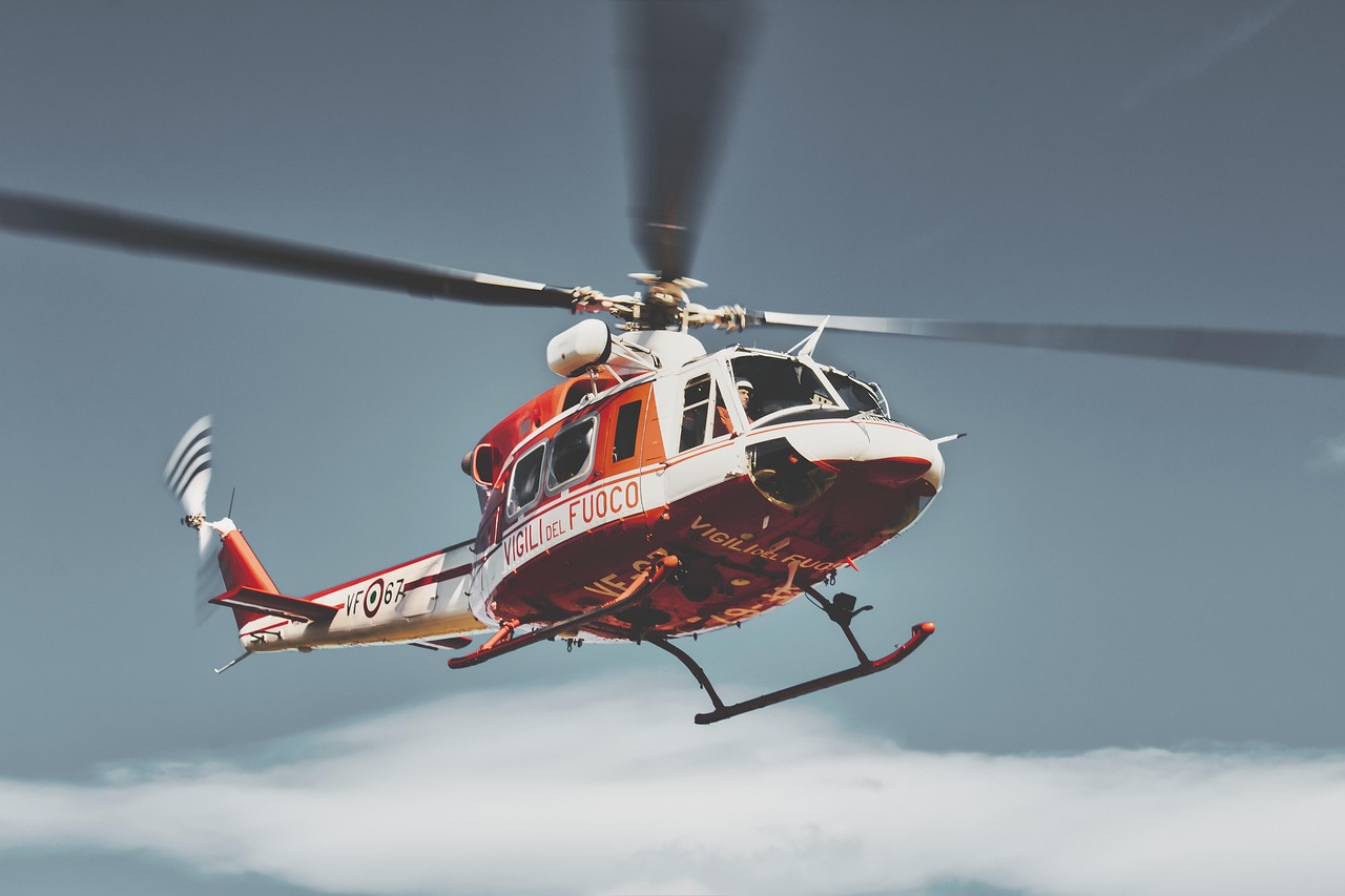 Red and white rescue helicopter in flight representing Helicopter loans, private jet financing, Cessna Caravan aircraft loans, how to finance a private jet purchase, and buying a jet with financing for aviation operators, emergency services, and aircraft owners.