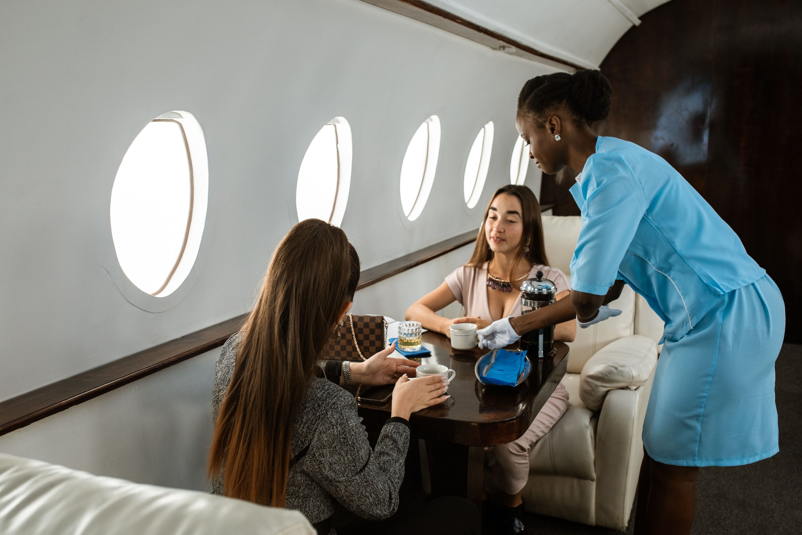 Luxury private jet cabin with premium in-flight service and executive passengers enjoying refreshments, representing HondaJet Financing, charter aircraft financing, midsize private aircraft financing, business aircraft ownership financing, and aircraft ownership loans for private aviation, corporate travel, and executive aircraft ownership.